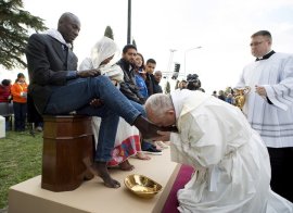 Pope Francis kisses the foot of a refugee during the foot-washing ritual at the Castelnuovo di Porto refugees center near Rome, Italy
